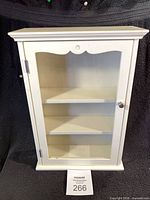 front view closed door of white display cabinet