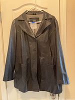 Full front view of black leather car coat on hanger