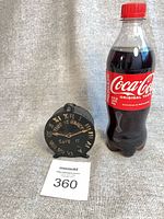 Coin bank shown beside 500 ml Coca-Cola bottle for scale, lot number card visible