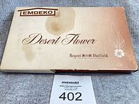 Closed Emdeko Desert Flower box top view showing branding and stains