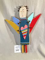 Full view of painted wooden angel wall hanging