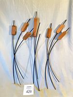 All three cattail sets showing wooden heads and curved black metal stems