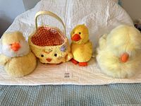 Full view of basket and three plush chicks on bed