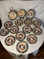 Front view of 15 Royal Crown Derby Imari plates set on table
