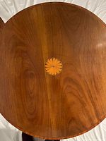 Top view showing round wood surface with central sunburst inlay