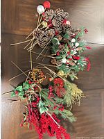 Group of artificial Christmas floral stems, picks, red berry branches, ornament accents and twig ring displayed on table