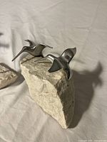 Two aluminum gull figurines on shared stone base