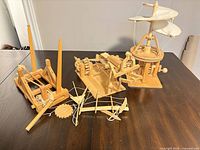Three assembled wooden Leonardo da Vinci machines on tabletop
