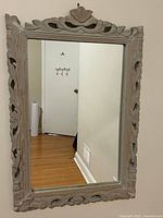 Front view of rectangular mirror showing carved wood frame and grey wash finish
