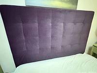 Front view of purple velvet queen headboard showing tufted grid pattern