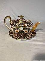 Teapot with lid on saucer showing overall design