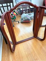 Front view of wood dresser mirror with two folding side mirrors