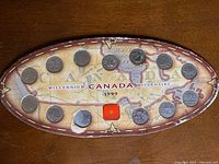 Full oval display card with all twelve coins and central medallion visible