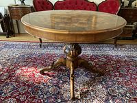 Entire table showing oval burr walnut top and carved pedestal base