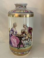 Front view showing courting couple at table scene, gold beading and floral bands