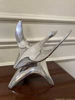 Front angled view showing bird form and polished finish
