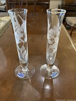 Both etched glass bud vases standing on table