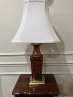 Lamp front view showing shade, vase body, brass base