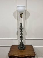 Full view of brass Stiffel torchiere table lamp on wooden stand