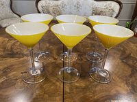 Six yellow martini glasses front view on table