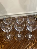 Group shot of all six crystal sherry glasses on wooden surface