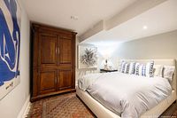 Bedroom scene showing full rug on floor beneath bed, displaying overall pattern and color