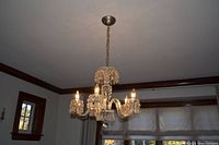 chandelier lit showing glass prisms and five arms