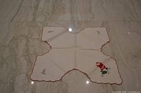 Full view of bread cover laid flat showing shape, trim and embroidery