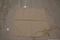 Single napkin laid flat showing embroidery corner and fabric texture