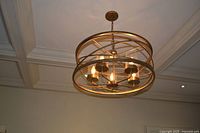 Full view of orb brass chandelier mounted to ceiling