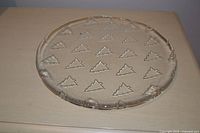 Top view of clear glass plate showing full circular shape and tree motif