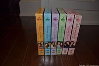 Six Gilmore Girls DVD boxed sets standing upright, spines visible, color-coded by season