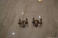 Both sconces side by side on floor showing design and bulbs