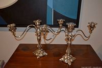 Pair of silver-plated candelabra on table showing size and design