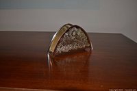 Front angled view showing engraved floral design and semicircular shape