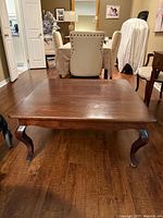 Full view of dark wood coffee table showing top surface and cabriole legs