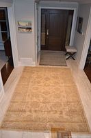 Full view of yellow floral area rug in hallway