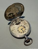 Open hunter-case pocket watch showing dial and case exterior