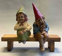 Front view of both gnomes seated on bench