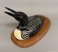 Left-front view of carved wooden loon on oval base