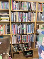 Front view of tall light wood veneer bookcase filled with books
