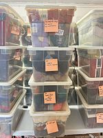 Stacked clear bins filled with yarn, sticky note counts visible