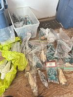 Bin and zip bags filled with assorted bottle brush trees in various colors and sizes