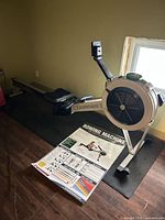 Full view of Concept2 Model D rower on mat with poster