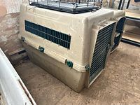 Overall view of beige plastic Vari Kennel showing front metal door and stacked cage on top