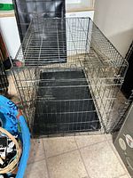 Overall view of folded wire crate with tray inside