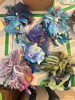 Top view of five handmade felt and fiber gnome/fairy dolls showing colors, textures, polymer clay legs and shoes