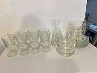 all 21 pieces grouped: goblets, bowls, plates, carafe
