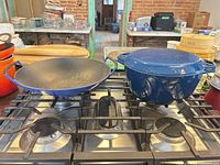 Blue enameled wok and Dutch oven on stovetop