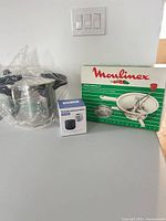 Pressure cooker in protective plastic, boxed food mill, boxed portable sealer